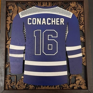 May include: A purple hockey jersey with white trim and the name "CONACHER" and number "16" on the front.