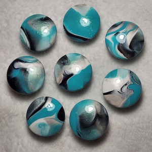 May include: Eight round, teal, black, and white marble-like ornaments with a glossy finish.