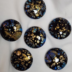 May include: Six round, black glass coasters with gold and blue abstract patterns.
