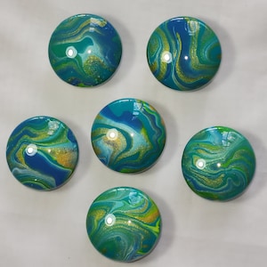 May include: Six round, blue, green, and gold marble-like ornaments with swirling patterns.
