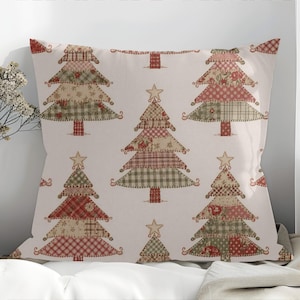 May include: A decorative pillow with a repeating pattern of Christmas trees. The trees are made of patchwork fabric in shades of red, green, and beige, with star toppers. The pillow has a neutral background and a festive, holiday theme.