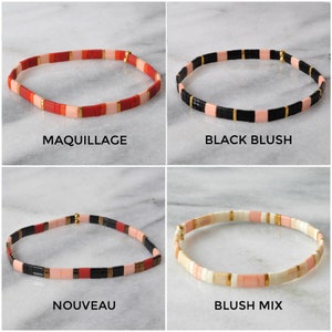 May include: Four different styles of colorful beaded bracelets. The bracelets are made with small, square beads in various colors, including pink, red, black, and white. The bracelets are arranged in a grid pattern, with each bracelet labeled with its name: "Maquillage", "Black Blush", "Nouveau", and "Blush Mix".