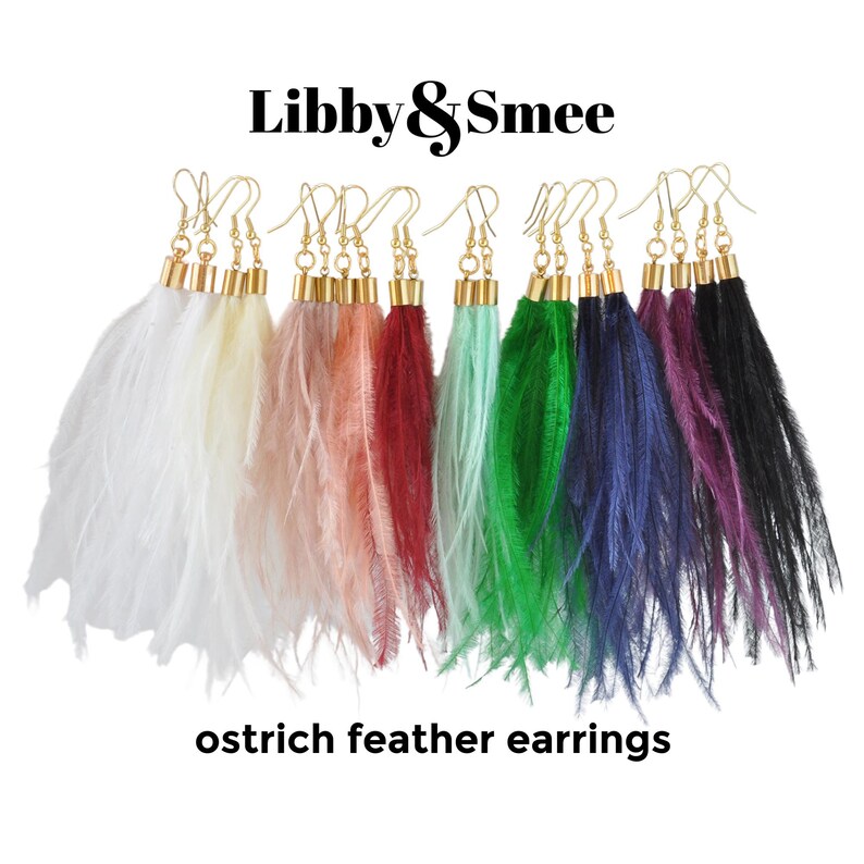 May include: A set of ten ostrich feather earrings in various colors, including white, cream, pink, red, mint green, dark green, navy blue, purple, and black. The earrings are all made with gold-toned metal.