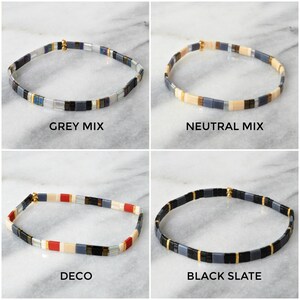 May include: Four different styles of tile bracelets, each with a different color scheme. The bracelets are made of small, square tiles with gold accents. The bracelets are arranged in a grid pattern, with each bracelet labeled with its name: Grey Mix, Neutral Mix, Deco, and Black Slate.