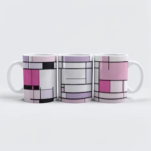 May include: Three white ceramic mugs with a geometric design in shades of pink, black, and white. The design features rectangular and square shapes separated by black lines, creating an abstract pattern. The mugs have a standard handle.