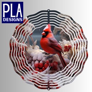 May include: A decorative metal wall hanging featuring a vibrant red cardinal bird perched on a snow-covered branch with red berries. The design is framed by a white, wave-like pattern. The text "PLA DESIGNS" is in the upper left corner.