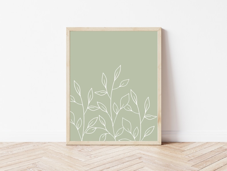 May include: A framed print with a minimalist design featuring white line drawings of leaves on a sage green background.