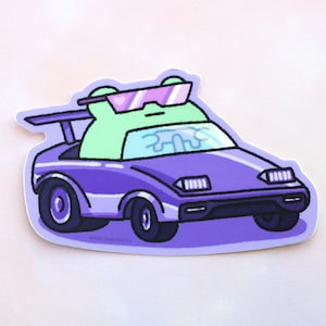 Peut inclure: Un autocollant repr&eacute;sentant une grenouille verte portant des lunettes de soleil et conduisant une voiture violette. La voiture a un aileron et des phares. La grenouille regarde droit devant.