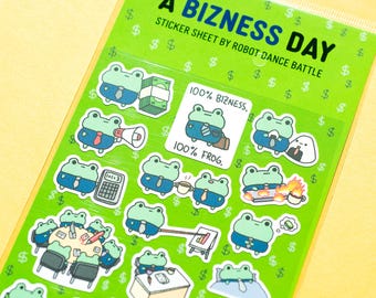 Może przedstawiać: Arkusz naklejek zatytułowany "A Bizness Day" autorstwa Robot Dance Battle. Arkusz zawiera różne ilustracje kreskówkowych żab w strojach biznesowych, ze znakami dolara jako wzorem tła. Niektóre naklejki mają tekst, np. "100% Bizness" i "100% Frog."