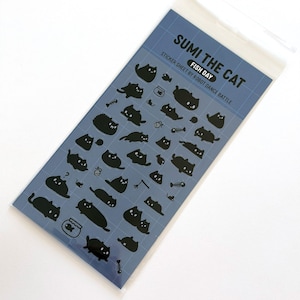 Peut inclure: Une planche d'autocollants avec des illustrations de chats noirs et des graphiques sur le thème du poisson sur fond bleu. Le texte "Sumi the Cat" et "Fish Day" est imprimé en haut. Les autocollants sont emballés dans une pochette plastique transparente.