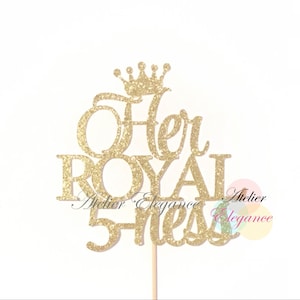 May include: Gold glitter cake topper with the words "Her Royal Highness" and a crown on top.