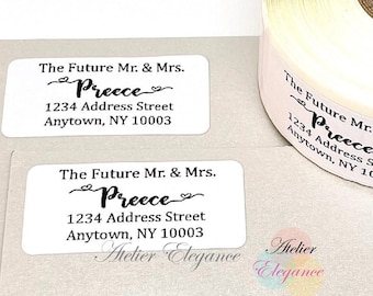 May include: Two white rectangular address labels with black text. The text reads "The Future Mr. & Mrs. Preece 1234 Address Street Anytown, NY 10003". The labels are printed with a decorative font and include a heart symbol.