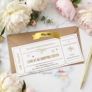 May include: A gift voucher with gold foil detailing, featuring the text "Real Foil" and "$300 AT AE SHOPPING CENTER." The voucher is in a brown envelope, surrounded by white and pink flowers. The text reads "To: Giovanna & Travis" and "From: Amelia & Edward."