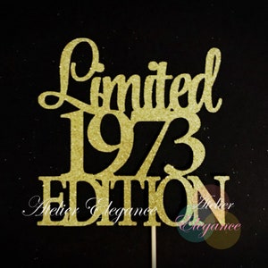 May include: Gold glitter cake topper with the text "Limited 1973 Edition" and the words "Atelier Elegance" at the bottom.