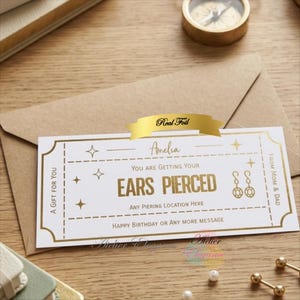 May include: A white gift certificate with gold foil text and accents, reading "You are getting your ears pierced." The certificate is in a brown envelope, with a gold ribbon that says "Real Foil".
