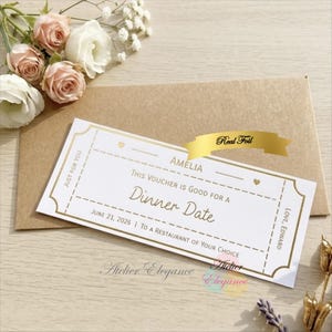May include: A white dinner date voucher with gold foil detailing, featuring the text "Dinner Date" and "Amelia." The voucher is on a brown envelope, with flowers in the background. The text "Real Foil" is on a gold ribbon.