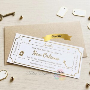 May include: A white and gold surprise gift ticket with the text "Amelia, Pack Your Bags! We Are Going to New Orleans". The ticket includes a passport icon and a small airplane graphic. The text "Real Foil" is on a gold banner.