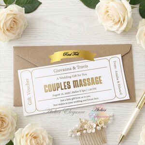 May include: A white rectangular gift voucher with gold foil text reading Couples Massage, Giovanna & Travis, and Atelier E Spa, placed on a brown envelope. The voucher includes details like the date 16 August 2026, and time 1:30 PM.