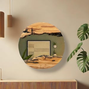 Puede incluir: Un espejo de pared circular con un marco de madera natural de borde vivo, con vetas prominentes y detalles de corteza oscura y texturizada. La superficie reflectante muestra el reflejo de una l&aacute;mina geom&eacute;trica enmarcada y dos macetas peque&ntilde;as.
