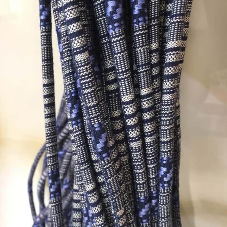 May include: A bundle of blue and white striped cords with a subtle pattern. The cords are tightly woven and have a smooth texture.