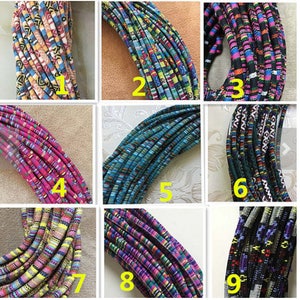 Puede incluir: Nueve cordones de tela tejida de diferentes colores, cada uno con un patrón único. Los cordones están dispuestos en una cuadrícula, con cada cordón numerado del 1 al 9.