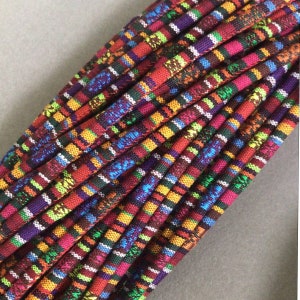 Può includere: Un fascio di cordini a righe colorati, con una varietà di colori vivaci, tra cui rosso, arancione, giallo, verde, blu, viola e bianco.