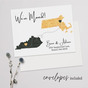 May include: A white card with a black and white illustration of a map of Kentucky and Massachusetts. The states are connected by a dotted line with a heart at each end. The text "We've Moved!" is at the top of the card. The text "Brian & Adrian" is below the map, along with an address. The text "envelopes included" is at the bottom of the card.
