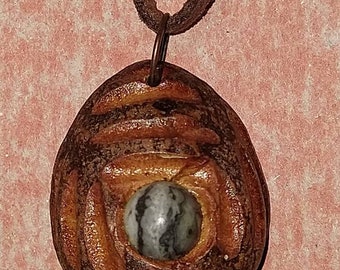 Hand carved avocado wood sculpture swirls and twirls with Stone. handmade yep hand carved unique and original only one. A lovely Pendant4u