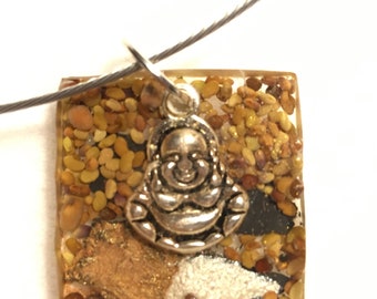Buddha and the seeds of dharma sitting on a rock encased in resin