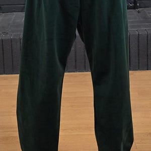 Puede incluir: Un pantal&oacute;n de ch&aacute;ndal verde oscuro de pierna recta.