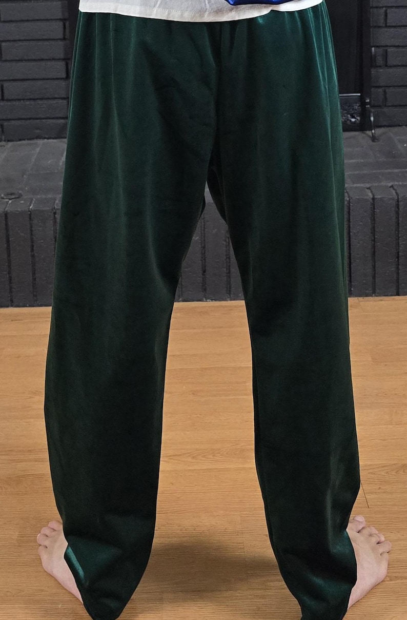 Puede incluir: Un pantal&oacute;n de ch&aacute;ndal verde oscuro de pierna recta.