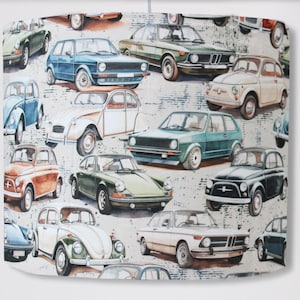 Może przedstawiać: Abażur w stylu vintage z kolorowym wzorem różnych klasycznych samochodów, w tym Volkswagenów, Fiatów i Porsche. Samochody są przedstawione w realistycznym stylu z detalicznym malowaniem i chromowanymi akcentami.