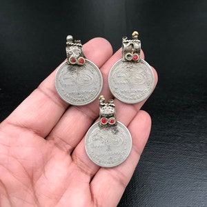 May include: Three silver pendants with red gemstones and ornate details. Each pendant features a circular design with the text "GOVERNMENT OF PAKISTAN" and the year "1969".