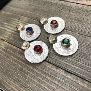 Puede incluir: Cuatro colgantes de plata con dise&ntilde;os ornamentados y piedras de vidrio de colores. Las piedras son rojas, azules, verdes y rojas.