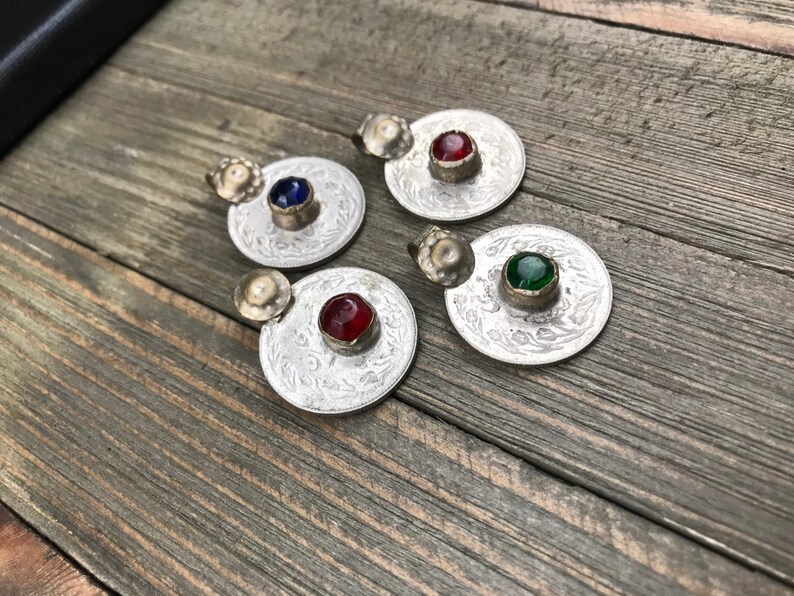 Puede incluir: Cuatro colgantes de plata con dise&ntilde;os ornamentados y piedras de vidrio de colores. Las piedras son rojas, azules, verdes y rojas.