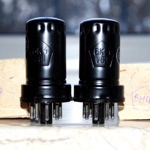 May include: Two black vacuum tubes with the text "6K4" and "6K4 V61" printed on them. The tubes are sitting on top of two cardboard boxes with the text "6K4" printed on them.