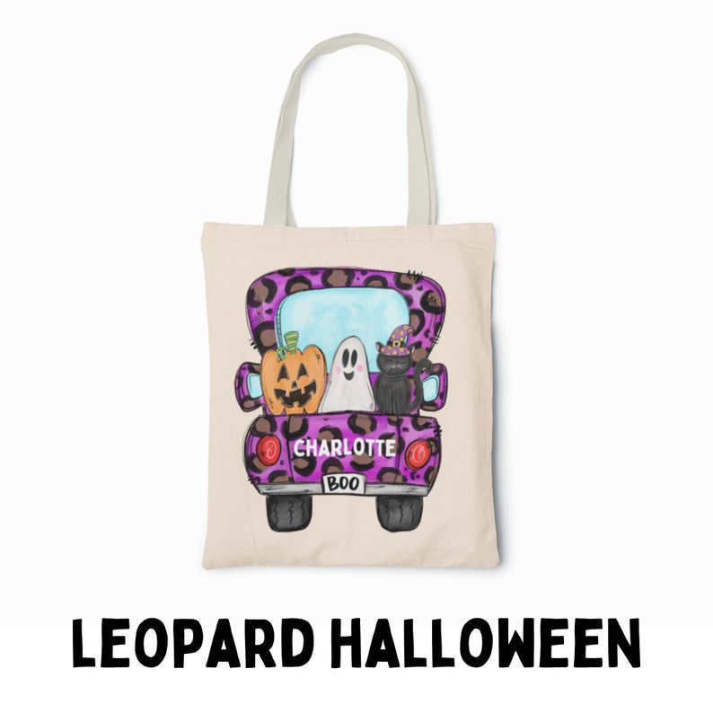 May include: A purple and black leopard print tote bag with a cartoon image of a pickup truck carrying a pumpkin, ghost, and black cat. The truck has the name "Charlotte" and the word "BOO" on the back.