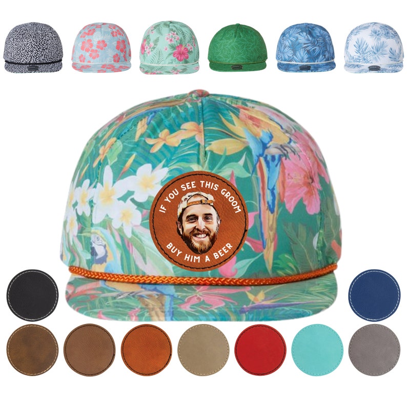 May include: A green, blue, and pink floral patterned baseball cap with a brown leather patch that says "If you see this groom buy him a beer". The patch has a photo of a man with a beard and brown hair. The cap has a black, brown, orange, beige, red, turquoise, and gray leather patch options.