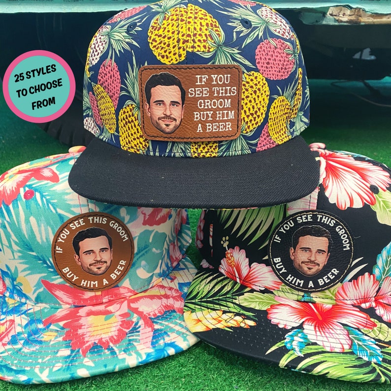 Puede incluir: Tres estilos diferentes de gorras de b&eacute;isbol con estampado tropical. Cada gorra tiene un parche redondo con la cara de un hombre y el texto "Si ves a este novio, c&oacute;mprale una cerveza".