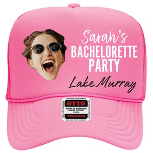 May include: Pink trucker hat with a photo of a woman wearing sunglasses and a white text overlay that says "Sarah's Bachelorette Party Lake Murray".