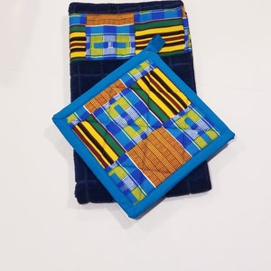 May include: A dark blue kitchen towel and matching square pot holder. Both items feature a vibrant patchwork design with blue, yellow, and red geometric patterns. The pot holder has a bright blue border.