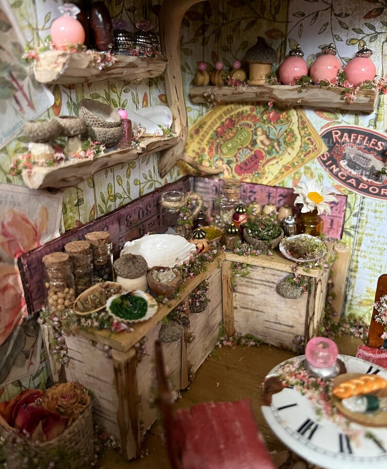 May include: A miniature kitchen with wooden cabinets and shelves, decorated with floral wallpaper and filled with small jars, bowls, and other items. The kitchen is decorated with a vintage floral pattern and a sign that reads "Raffles Singapore".