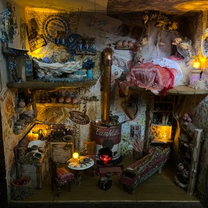 May include: A miniature dollhouse with a detailed interior, featuring a kitchen with a stove, a dining area with a table and chairs, and a bedroom with a bed and a canopy. The dollhouse is decorated with vintage-inspired wallpaper and furniture, and includes small details like a miniature can of Campbell's soup and a miniature lamp.