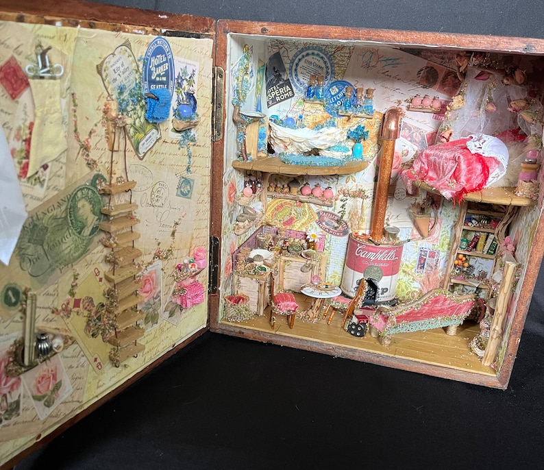 May include: A miniature dollhouse scene featuring a red velvet chaise longue, a wood-burning stove, and a Campbell's soup can. The dollhouse is decorated with vintage wallpaper and floral accents.