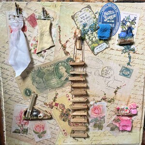 May include: A vintage-inspired collage featuring a miniature wooden ladder, a small white dress, a blue fabric flower, and a variety of paper ephemera, including a Bank of England one pound note, a playing card, and a vintage postcard.