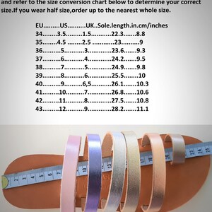 May include: A size conversion chart for flat sandals, showing European, US, and UK sizes, along with insole length in centimeters and inches. The chart is printed on a white background. A close-up of five sandals in different colors, pink, purple, silver, gold, and beige, are laid out on a brown leather surface with a measuring tape.