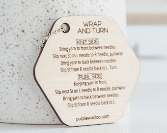 May include: A wooden, hexagonal knitting guide with a silver chain. The guide has instructions for the "Wrap and Turn" technique, including "Knit Side" and "Purl Side" steps. The website purplewoolco.com is printed at the bottom.
