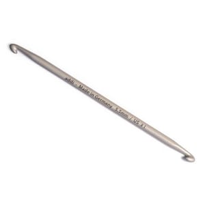 May include: A silver crochet hook with a 5.5mm size, labeled "addi - Made in Germany 5.5mm / US #1".