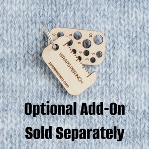 May include: A wooden gauge with a ring for attaching to a keychain. The gauge has a ruler marked "Wraps Per Inch" and a series of holes for measuring the gauge of yarn. The text "purplewoolco.com" is printed on the gauge. The text "Optional Add-On Sold Separately" is printed below the gauge.
