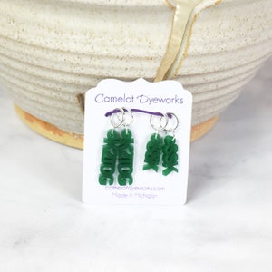 May include: Two sets of green letter stitch markers, one set says "KNIT" and the other says "&" and "YARN". The stitch markers are on a white card with the text "Camelot Dye Works" and "camelotdyeworks.com Made in Michigan".